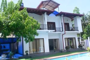 a house with a swimming pool in front of it at Madu Rivora Villa in Ambalangoda