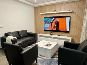 a living room with black furniture and a flat screen tv at Appart Angel in Espargos