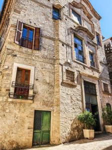 an old stone building with green doors and windows at Il Chiostro di Ribot in Lugnano in Teverina
