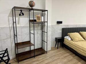 a black book shelf next to a bed in a room at URDAIHOME SUITES & BIKEs in Guernica y Luno