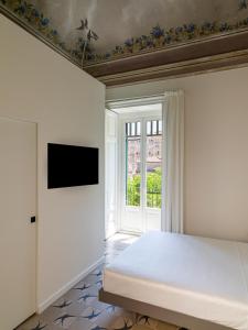 a bedroom with a bed and a tv on a wall at Palazzo Settanta in Catania