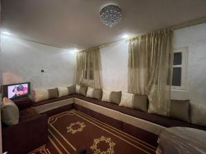 a living room with a couch and a tv at maison souk agadir in Agadir