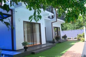 a house with a green lawn in front of it at Madu Rivora Villa in Ambalangoda
