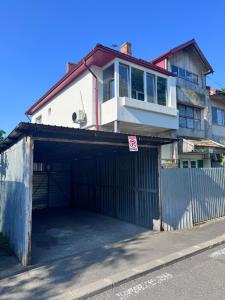 a building with a garage in front of a house at V apartament - ultra central Otopeni in Otopeni