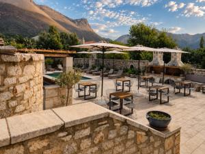 a patio with tables and chairs and an umbrella at Areos Polis Boutique Hotel in Areopoli