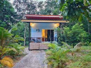 a tiny house in the middle of a forest at Blue Cottage Koh Kood a Quiet Tropical Getaway in Ban Lak Uan +3 photos