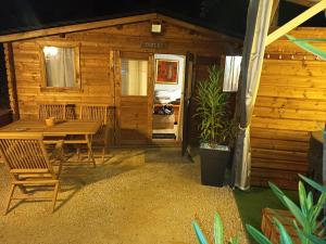 a table and chairs in front of a cabin at Chalet Les Buis in Saint-Paul-lès-Romans