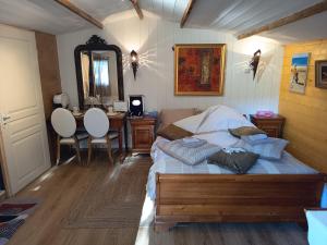 a bedroom with a bed and a table and a mirror at Chalet Les Buis in Saint-Paul-lès-Romans +38 photos