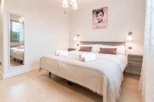 a white bedroom with a large bed and a mirror at Casa Turística la Almunia in Castellanos de Moriscos +38 photos