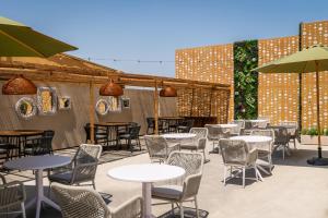 a patio with tables and chairs and umbrellas at ALEGRIA Cartago Nova in Malgrat de Mar