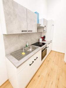 a kitchen with white cabinets and a sink at City Apartment 1 in Vienna