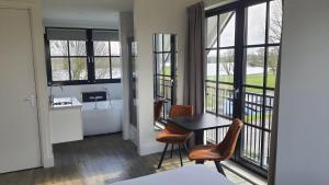 a room with a table and chairs and windows at Sientjes Boetiekhotel in Kerkdriel