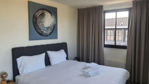 a bedroom with a bed with two towels on it at Sientjes Boetiekhotel in Kerkdriel +79 photos
