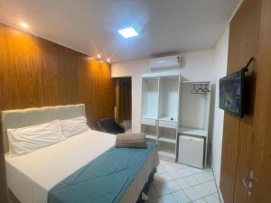 a small bedroom with a bed and a television at Pousada Terraço das Aguas in Maceió +24 photos