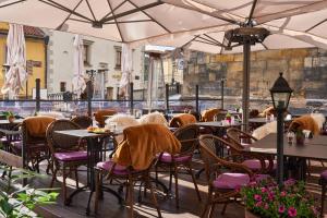 an outdoor restaurant with tables and chairs and umbrellas at Hotel Pod Věží in Prague