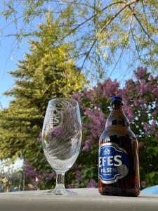 a bottle of beer sitting next to a wine glass at Akar Hotel in Ihlara +41 photos