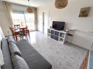 una sala de estar con un sofá y un televisor en CUNIT PLaYA, en Cunit