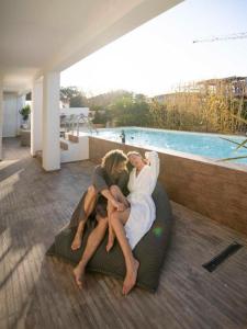 zwei Personen sitzen auf einem Sofa auf einem Balkon in der Unterkunft Le Stanze e il Mare in Polignano a Mare