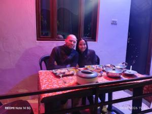 a man and a woman sitting at a table at mayur homestay in Ukhimath +88 photos