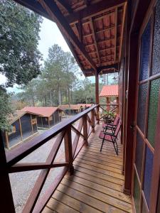 a porch of a house with chairs on it at Cinque chalé in São Roque