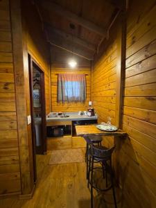 a kitchen with a sink and a table in a cabin at Cinque chalé in São Roque