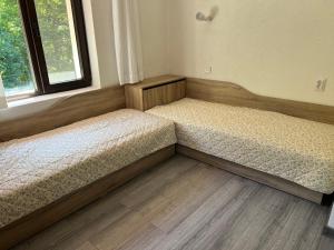 two beds sitting in a room with a window at Къща за гости Зафирови in Ribarica