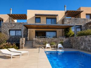 a villa with a swimming pool in front of a house at Óros Residence - Pool & Panoramic Views in Tzíkidhes