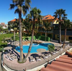 an overhead view of a resort pool with chairs and palm trees at Apartamentos Atlántico Resort in Montalvo