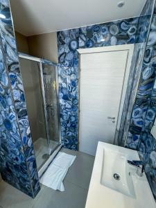 a bathroom with a glass shower and a sink at Beach House - Affittacamere Paola in Paola