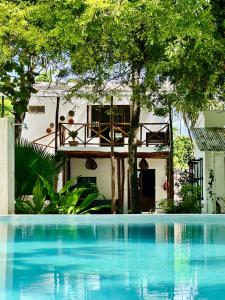 a house with a swimming pool in front of a house at Garden Beach Bungalows Jambiani in Jambiani