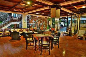 a lobby with a table and chairs and a couch at Puri Naga Beachfront Cottages in Legian
