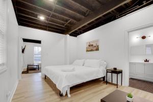 a white bedroom with a bed and a table at The Neuschwanstein Flat- Walkable in Columbus