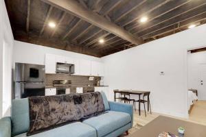 a living room with a blue couch and a kitchen at The Neuschwanstein Flat- Walkable in Columbus