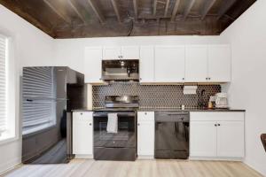 a kitchen with white cabinets and stainless steel appliances at The Neuschwanstein Flat- Walkable in Columbus