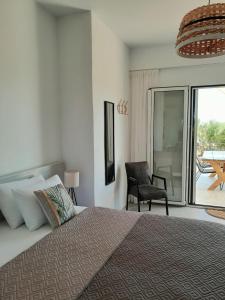 a bedroom with a bed and a chair and a balcony at Sunsets and Olive Trees in Messini +54 photos