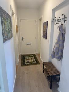 a hallway with a door and a rug on the floor at Hygge Home Aalborg, Free Parking & 15 Min to City Centre in Nørresundby +1 photo