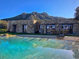 a stone house with a pool in front of it at Casa Campo Longo in Belgodère