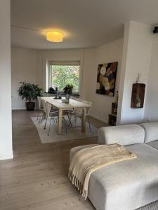 a living room with a table and a couch at Hygge Home Aalborg, Free Parking & 15 Min to City Centre in Nørresundby