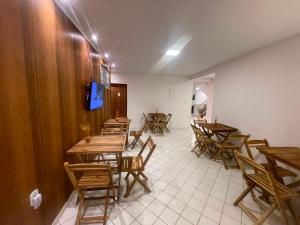 a dining room with wooden tables and chairs at Pousada Terraço das Aguas in Maceió