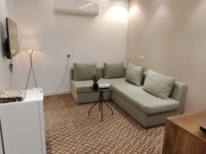 a living room with a couch and a table at Roaa Al-Jamwaut in Medina +10 photos