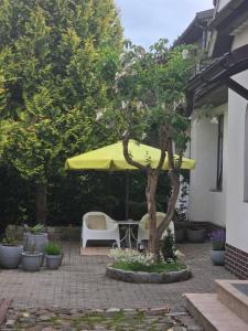 a patio with a table and a yellow umbrella at Molas svečių namai in Klaipėda +13 photos