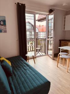 a bedroom with a bed and a view of a balcony at Apartamenty Nadmorska in Rowy