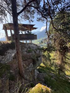 a building on top of a hill with a tree at Dachboden Loft in Laax
