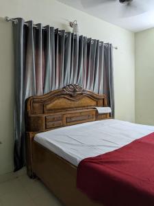 a bedroom with a wooden bed with a curtain at walking distance from temble in Guruvāyūr