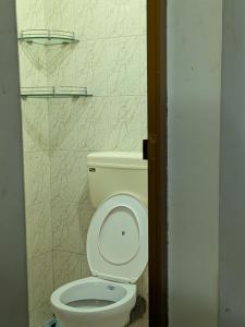a bathroom with a white toilet in a room at walking distance from temble in Guruvāyūr +8 photos