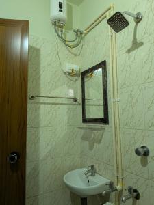 a bathroom with a sink and a mirror at walking distance from temble in Guruvāyūr
