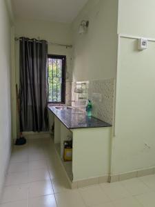 a kitchen with a counter top and a window at walking distance from temble in Guruvāyūr