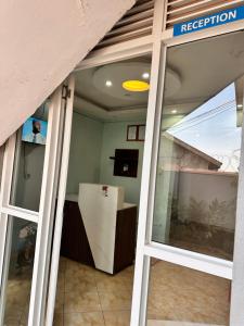 an open door to a room with a reflection in a window at Zone hotel and guest house in Bugembe