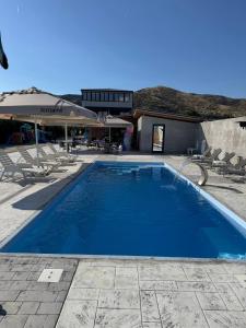 a large blue swimming pool next to a building at Bran Apartments in Star Dojran