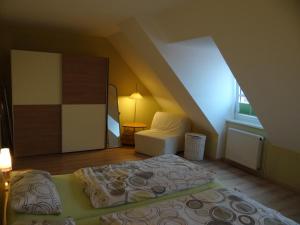 a bedroom with a bed and a chair in a attic at Darssblick Barth - Boddenblick, Tiefgarage & Aufzug in Barth
